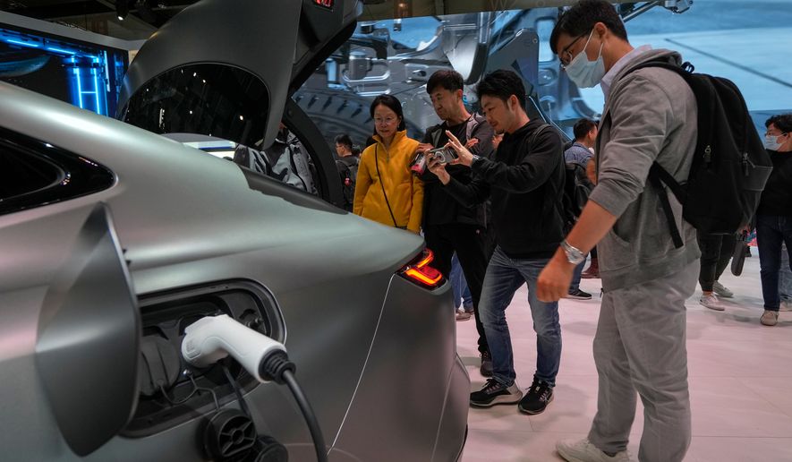 FILE - Visitors look at a Geely Galaxy E8 electric car during the Auto China 2024 in Beijing, Sunday, April 28, 2024. (AP Photo/Andy Wong, File)