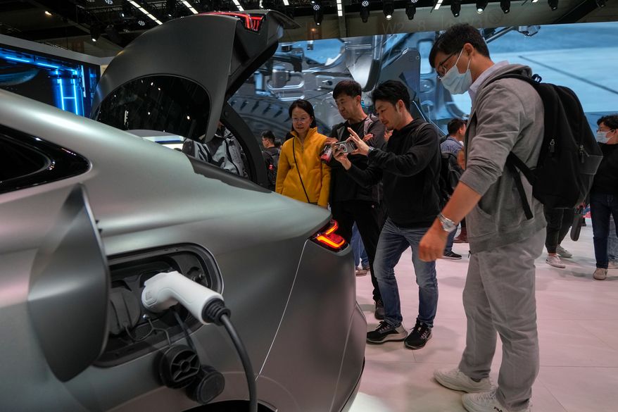 FILE - Visitors look at a Geely Galaxy E8 electric car during the Auto China 2024 in Beijing, Sunday, April 28, 2024. (AP Photo/Andy Wong, File)