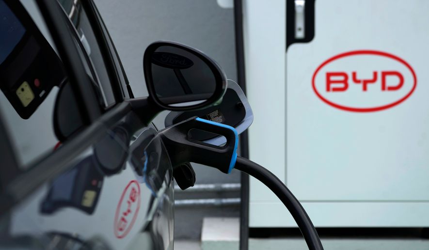 A BYD electric vehicle charges at a dealership in Camacari, Bahia state, Brazil, Friday, March 7, 2025. (AP Photo/Eraldo Peres, File)