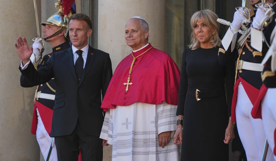 Pope Leo XIV, center, is welcomed by French President Emmanuel Macron, left, and his wife Brigitte as he arrives at the Elysee Palace in Paris, Friday, Sept. 25, 2026. (AP Photo/Gregorio Borgia)