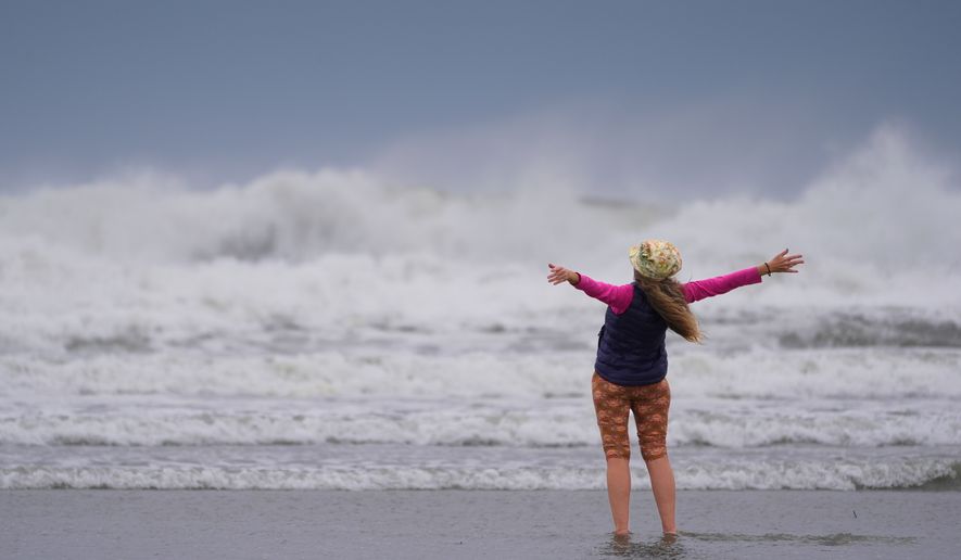 Brenda Malloy enjoys a nor'easter storm, Friday, Sept. 25, 2026, in Gloucester, Mass. (AP Photo/Robert F. Bukaty)