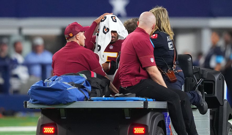 Washington Commanders quarterback Jayden Daniels (5) is carted off the field after an apparent injury in the first half against the Dallas Cowboys during an NFL football game in Arlington, Texas, Sunday, Sept. 20, 2026. (AP Photo/Julio Cortez)