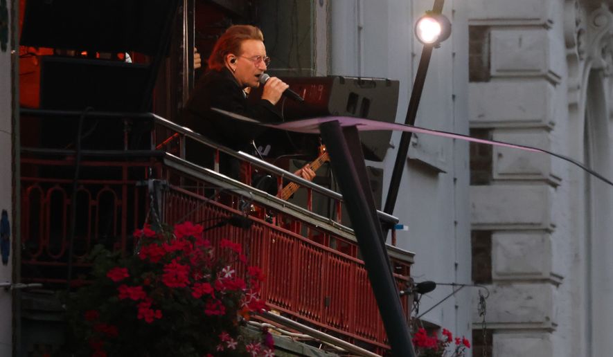 U2 perform an impromptu concert from a balcony in central Dublin, Ireland , Friday, Sept. 25, 2026. (AP Photo/Peter Morrison)