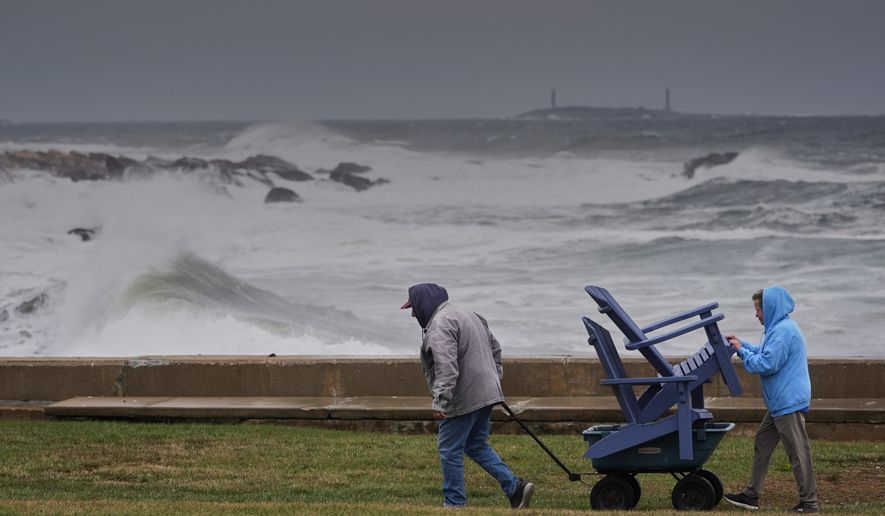 Chuck and Teresa Palmieri move lawn furniture to a safe location at a relative's seaside property as the Atlantic Ocean kicks up surf during the early stages of a nor'easter storm, Friday, Sept. 25, 2026, in Gloucester, Mass. (AP Photo/Robert F. Bukaty)