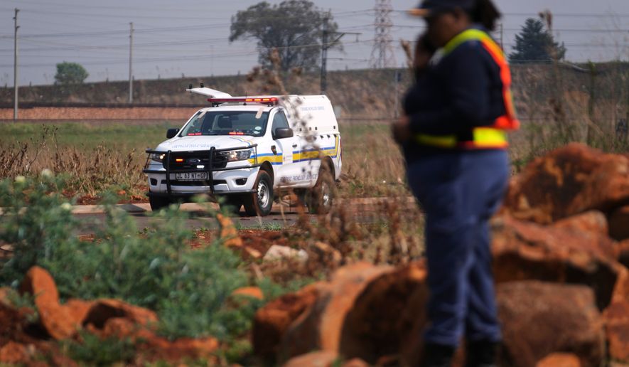 Forensic investigators work at the site where the body of a woman was discovered on the outskirts of Johannesburg, South Africa, Thursday, Sept. 17, 2026. (AP Photo/Themba Hadebe)