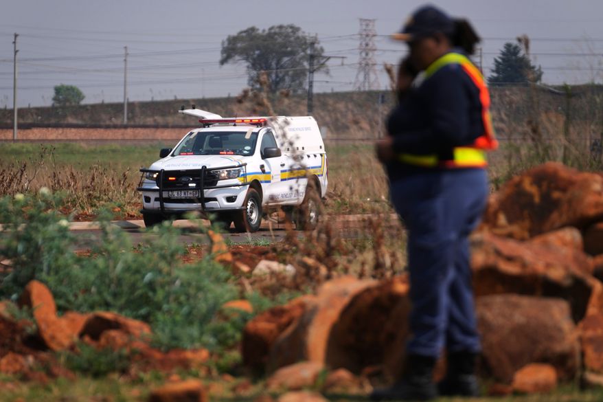 Forensic investigators work at the site where the body of a woman was discovered on the outskirts of Johannesburg, South Africa, Thursday, Sept. 17, 2026. (AP Photo/Themba Hadebe)