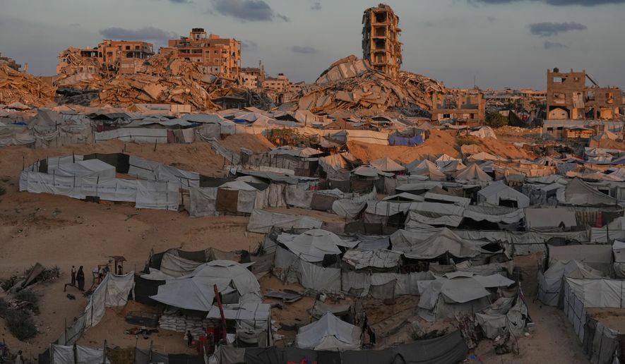 Tents sheltering displaced Palestinians are seen amid war-damaged buildings in Gaza City, Saturday, Sept. 26, 2026. (AP Photo/Jehad Alshrafi)