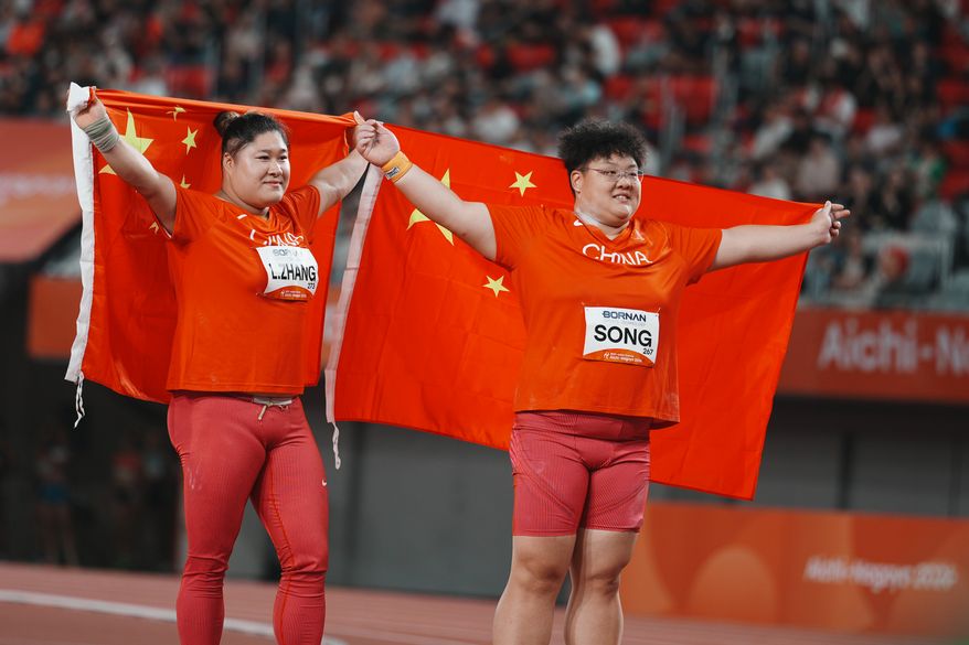 China's Song Jiayuan, right, and Zhang Linru hold their flags after competing in the women's shot put final at the Asian Games in Nagoya, Japan, Friday, Sept. 25, 2026. (AP Photo/Lee Jin-man)