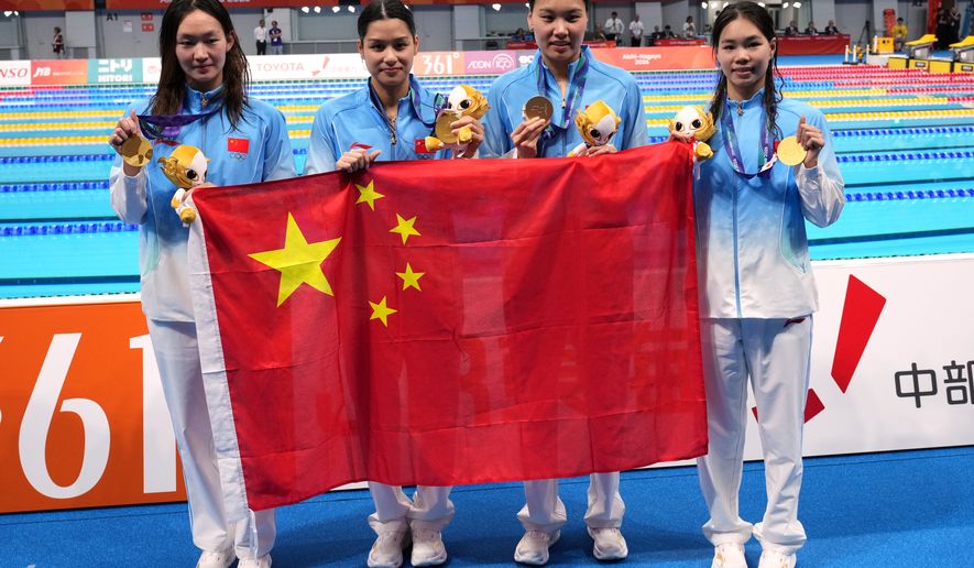 Gold medalist, China team, pose with their national flag, after the women's 4 x 200-meter freestyle relay final in swimming at the Asian Games in Tokyo, Japan, Thursday, Sept. 24, 2026. (AP Photo/Hiro Komae)
