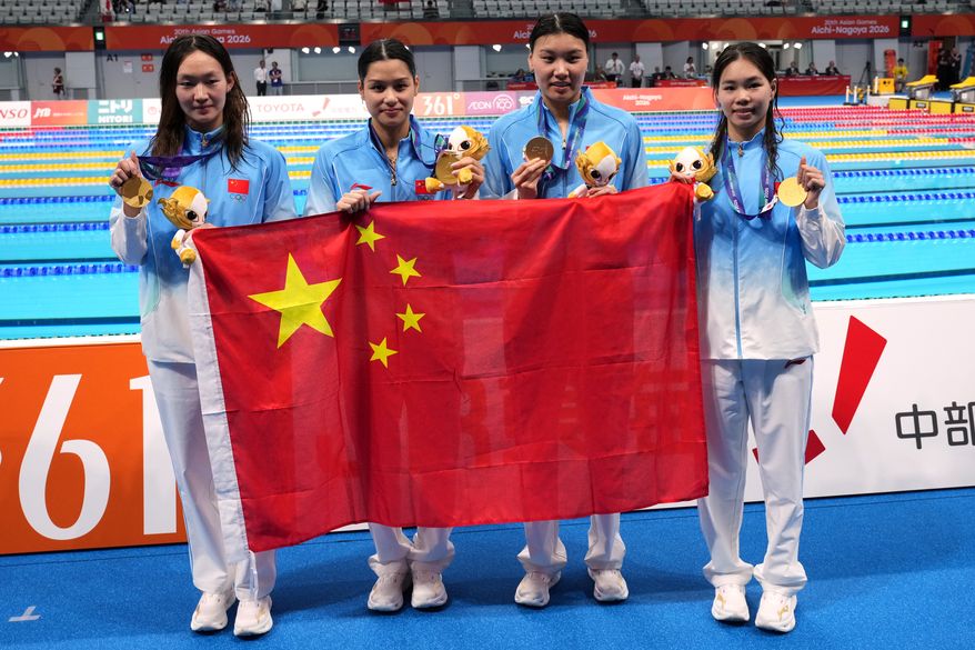 Gold medalist, China team, pose with their national flag, after the women's 4 x 200-meter freestyle relay final in swimming at the Asian Games in Tokyo, Japan, Thursday, Sept. 24, 2026. (AP Photo/Hiro Komae)