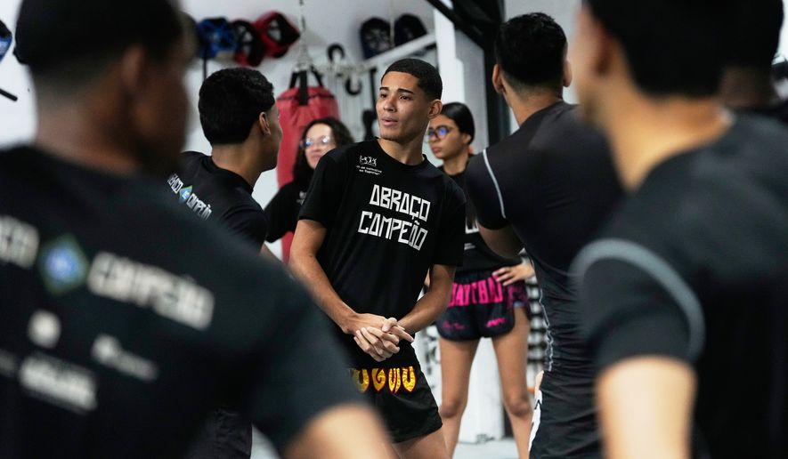 Youth attend a martial arts class at Abraco Campeao, or Embrace Champions, an academy that offers free boxing, jiu-jitsu, Muay Thai and capoeira classes, as well as educational talks on topics ranging from environmental issues to relationships, in the Complexo de Alemao favela in Rio de Janeiro, Wednesday, Sept. 16, 2026. (AP Photo/Silvia Izquierdo)