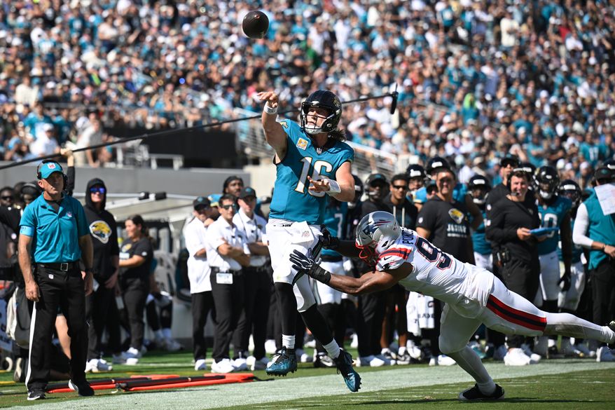 Jacksonville Jaguars quarterback Trevor Lawrence (16) passes against New England Patriots linebacker Elijah Ponder (91) in the second half during an NFL football game in Jacksonville, Fla., Sunday, Sept. 27, 2026. (AP Photo/Phelan M. Ebenhack)