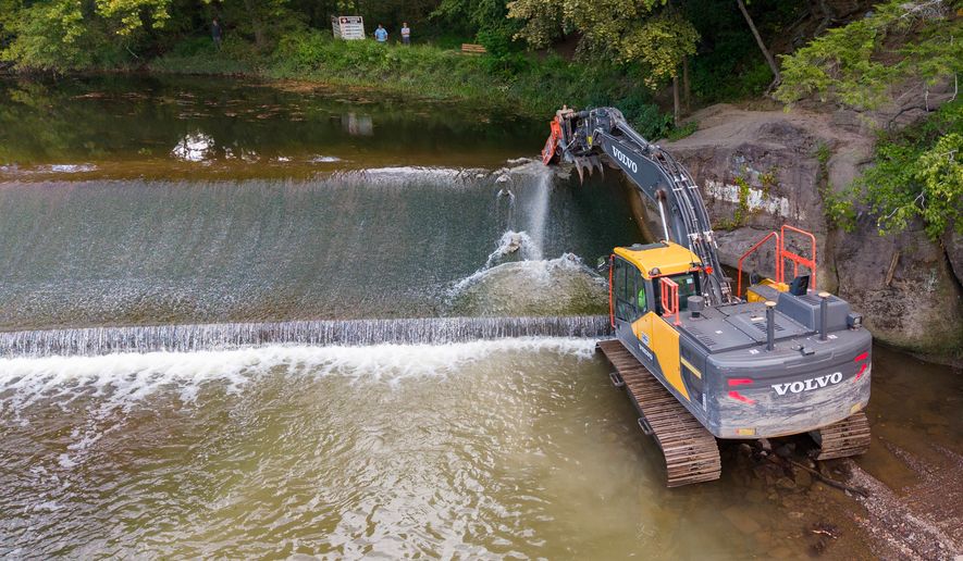 A crew demolishes the Spring Garden Dam at a historic mill site on Neshaminy Creek in Newtown, Pa., Thursday, Sept. 10, 2026, as heavier downpours linked to climate change put greater pressure on aging infrastructure; more than twice as many dams have been removed in Pennsylvania as in any other U.S. state, according to American Rivers' national dam-removal database. (AP Photo/Ted Shaffrey)