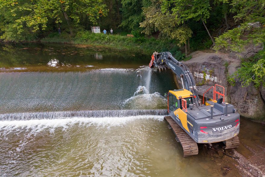 A crew demolishes the Spring Garden Dam at a historic mill site on Neshaminy Creek in Newtown, Pa., Thursday, Sept. 10, 2026, as heavier downpours linked to climate change put greater pressure on aging infrastructure; more than twice as many dams have been removed in Pennsylvania as in any other U.S. state, according to American Rivers' national dam-removal database. (AP Photo/Ted Shaffrey)