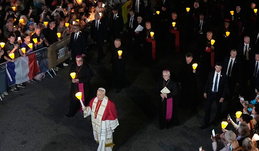 Pope Leo XIV, center, holds a candle during a prayer of Holy Rosary and torchlight procession at the Sanctuary of Our Lady of Lourdes, France, Sunday, Sept. 27, 2026. ((AP Photo/Laurent Cipriani)
