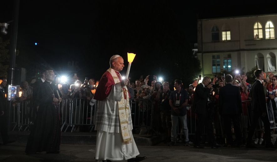Pope Leo XIV holds a candle during a prayer of Holy Rosary and torchlight procession at the Sanctuary of Our Lady of Lourdes, France, Sunday, Sept. 27, 2026. (AP Photo/Thibault Camus)