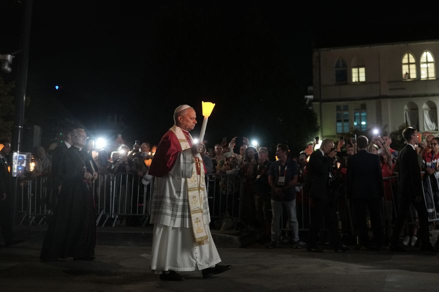 Pope Leo XIV holds a candle during a prayer of Holy Rosary and torchlight procession at the Sanctuary of Our Lady of Lourdes, France, Sunday, Sept. 27, 2026. (AP Photo/Thibault Camus)