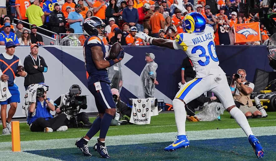 Denver Broncos wide receiver Jaylen Waddle, left, catches a touchdown pass against Los Angeles Rams cornerback Josh Wallace during the second half of an NFL football game Sunday, Sept. 27, 2026, in Denver. (AP Photo/David Zalubowski)