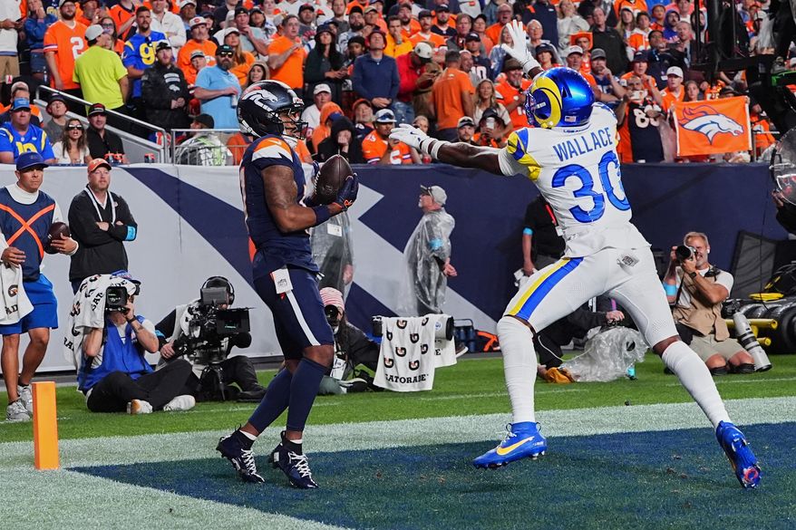 Denver Broncos wide receiver Jaylen Waddle, left, catches a touchdown pass against Los Angeles Rams cornerback Josh Wallace during the second half of an NFL football game Sunday, Sept. 27, 2026, in Denver. (AP Photo/David Zalubowski)