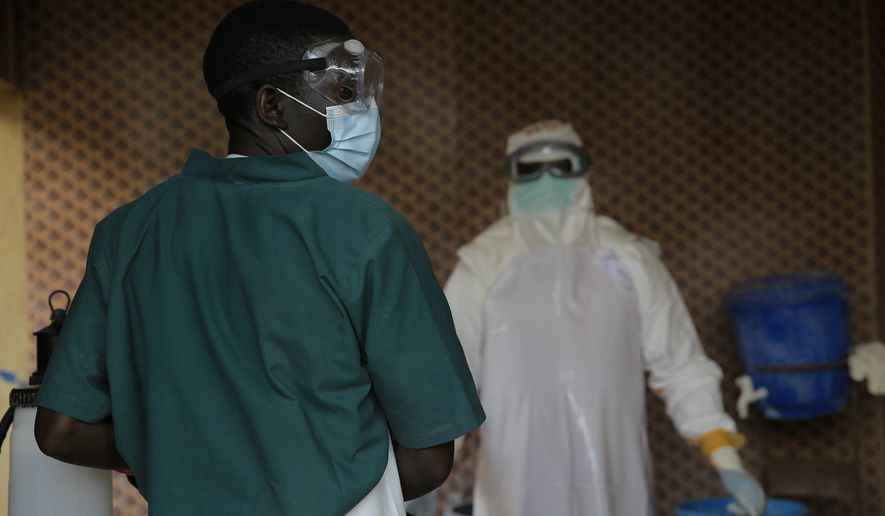 A healthcare worker is disinfected by his colleague inside a treatment center for Ebola patients in Beni, North Kivu province, eastern Congo, Saturday, Sept. 26, 2026. (AP Photo/Sebastien Kitsa Musayi)