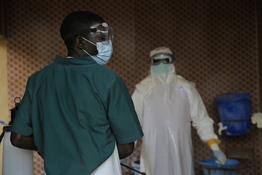 A healthcare worker is disinfected by his colleague inside a treatment center for Ebola patients in Beni, North Kivu province, eastern Congo, Saturday, Sept. 26, 2026. (AP Photo/Sebastien Kitsa Musayi)