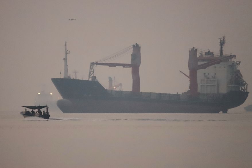 A motorboat passes an anchored cargo ship in the Strait of Hormuz off Bandar Abbas, Iran, early Monday, Sept. 28, 2026. (Amirhosein Khorgooi/ISNA via AP)