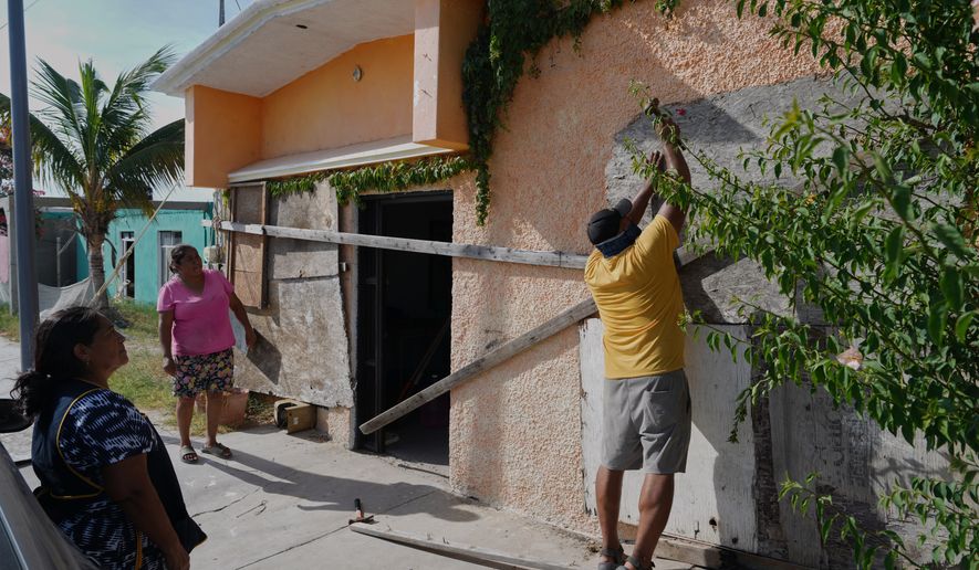 A man boards up a house's windows as Hurricane Polo approaches in Puerto San Carlos, Baja California Sur state, Mexico, Sunday, Sept. 27, 2026. (AP Photo/Eduardo Verdugo)