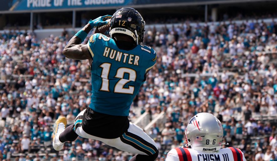 Jacksonville Jaguars wide receiver Travis Hunter (12) intercepts a pass against New England Patriots wide receiver Efton Chism III (86) in the first half during an NFL football game in Jacksonville, Fla., Sunday, Sept. 27, 2026. (AP Photo/Mike Stewart)