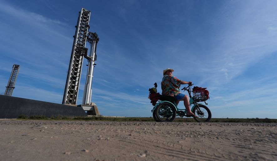 David Orr rides his bike past SpaceX's mega rocket Starship as it is prepared for a test flight from Starbase, Texas, Sunday, Sept. 27, 2026. (AP Photo/Eric Gay)