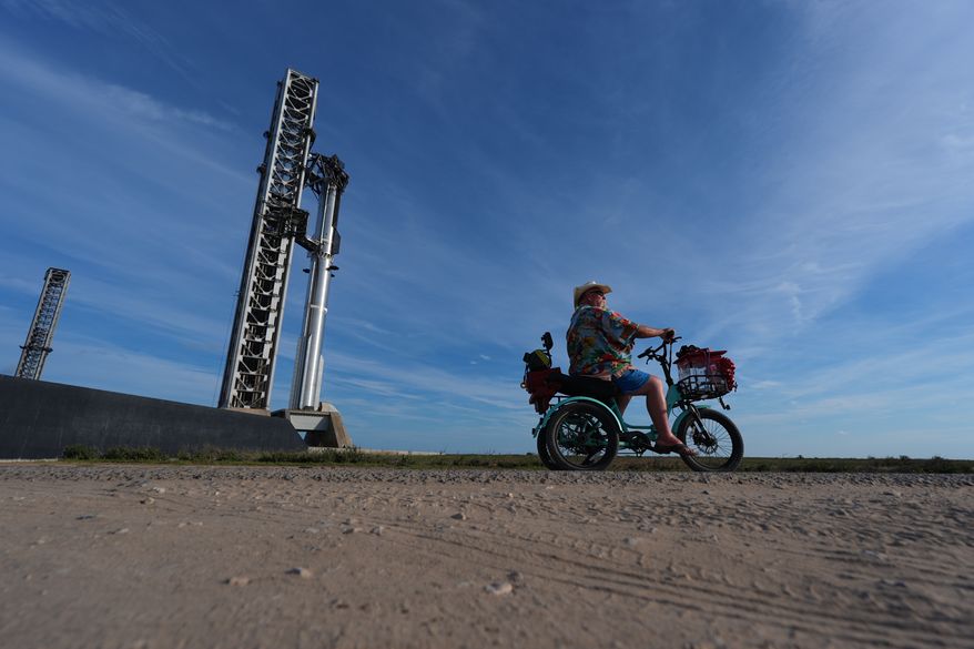 David Orr rides his bike past SpaceX's mega rocket Starship as it is prepared for a test flight from Starbase, Texas, Sunday, Sept. 27, 2026. (AP Photo/Eric Gay)