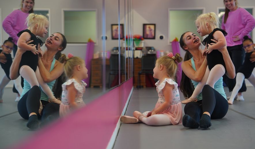 From left, Amelia Woods sits in front as Samantha Hatch holds Elsie Bickett, while Maliyah Rider stands next to Claire Graham in front of a mirror during a Dance Abilities class at the Academy of Dance Arts in the Indianapolis suburb of Fishers, Ind., Thursday, Sept. 17, 2026. (AP Photo/Obed Lamy)