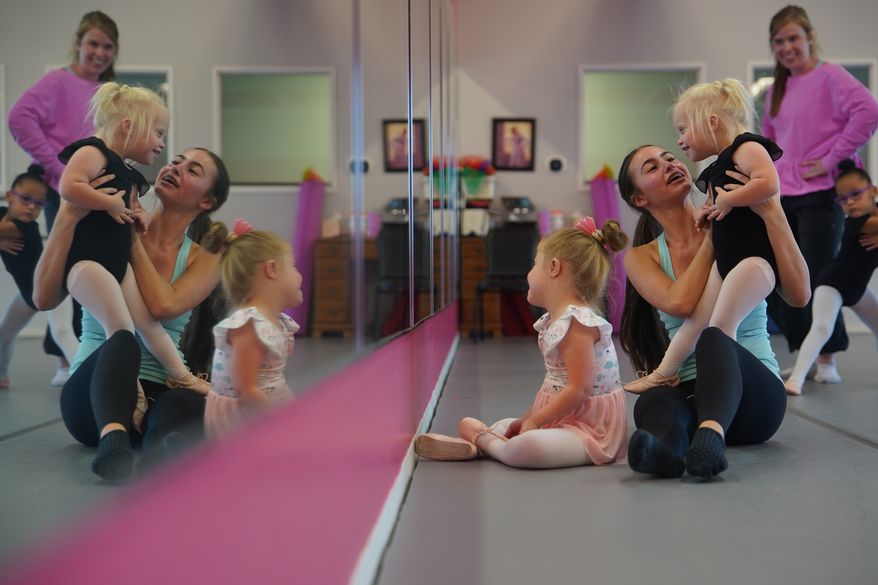 From left, Amelia Woods sits in front as Samantha Hatch holds Elsie Bickett, while Maliyah Rider stands next to Claire Graham in front of a mirror during a Dance Abilities class at the Academy of Dance Arts in the Indianapolis suburb of Fishers, Ind., Thursday, Sept. 17, 2026. (AP Photo/Obed Lamy)