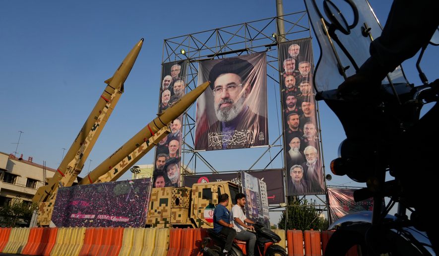 Motorbikes drive past Iranian missiles and banners showing portraits of the Iranian Supreme Leader Ayatollah Mojtaba Khamenei, center, and the late armed forces commanders and nuclear scientists, who were killed in Israeli and U.S. strikes, displayed in a military exhibition commemorating the anniversary of the start of the 1980-88 Iraq-Iran war at Baharestan Square, in Tehran, Monday, Sept. 28, 2026. (AP Photo/Vahid Salemi)