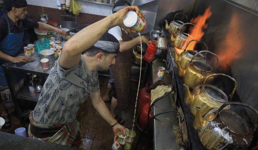 A tea seller pours milk from a can as he prepares tea at a market in Houthi-controlled Sanaa, Yemen, Monday, Sept. 28, 2026. (AP Photo/Osamah Abdulrahman)