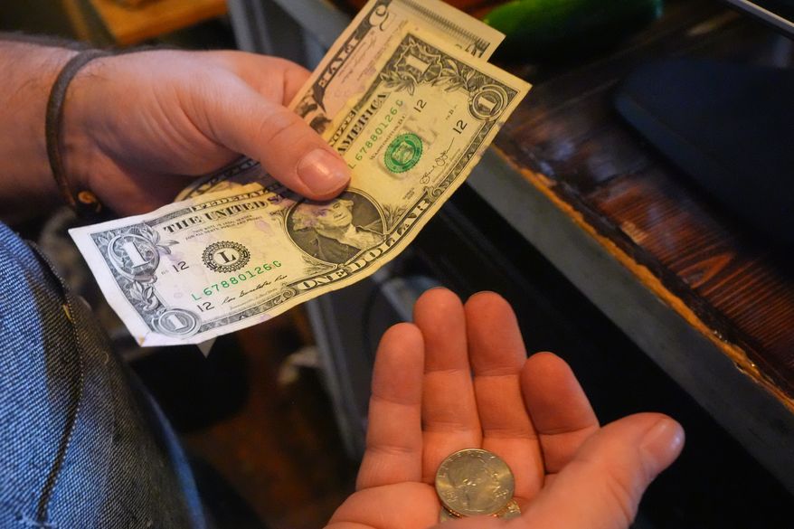 Change is made after a sale at a produce market in downtown Dallas, Tuesday, Sept. 29, 2026. (AP Photo/LM Otero)