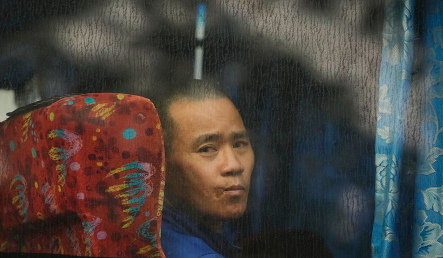 One of Myanmar nationals looks out from a bus in Manjung, Perak state of Malaysia, on Tuesday, Sept. 29, 2026. (AP Photo/Vincent Thian)