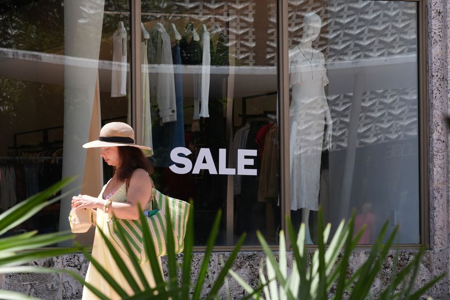A pedestrian walks past a clothing store with items on sale Thursday, Sept. 3, 2026, in Miami Beach, Fla. (AP Photo/Marta Lavandier)