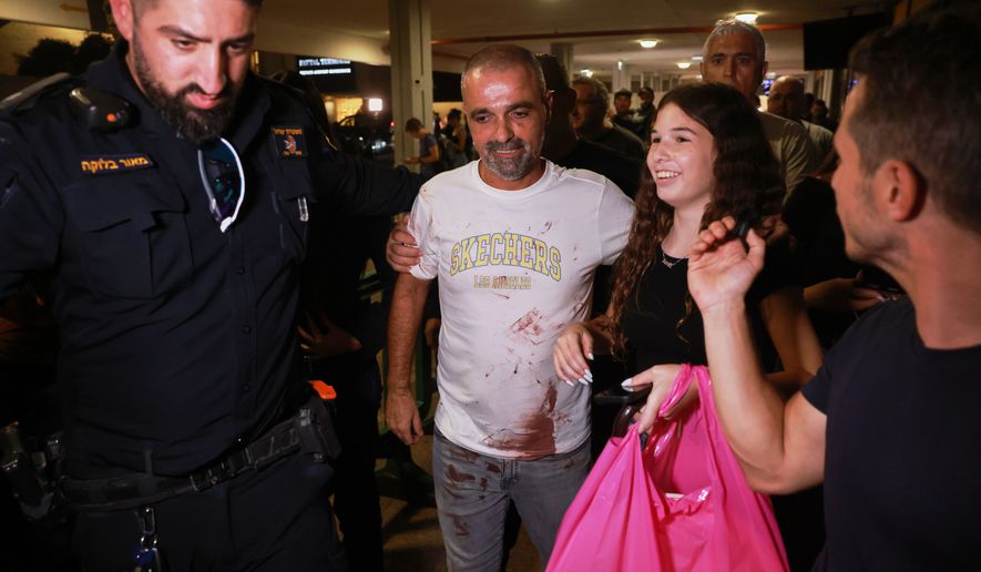 Israeli passenger Yaniv Hayoun, with blood stains on his shirt, who was aboard a Flydubai aircraft that made an emergency landing in Saudi Arabia, is welcomed at the arrivals gate at Ben Gurion International Airport near Tel Aviv, Israel, Wednesday, Sept. 30, 2026. (AP Photo/Tomer Appelbaum)