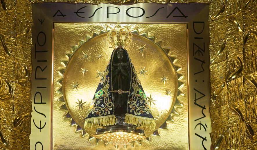 The statue of Brazil's patron saint, the Virgin of Aparecida, stands behind glass inside the basilica named after her in the town of Aparecida, Brazil, July 23, 2013. (AP Photo/Andre Penner, File)