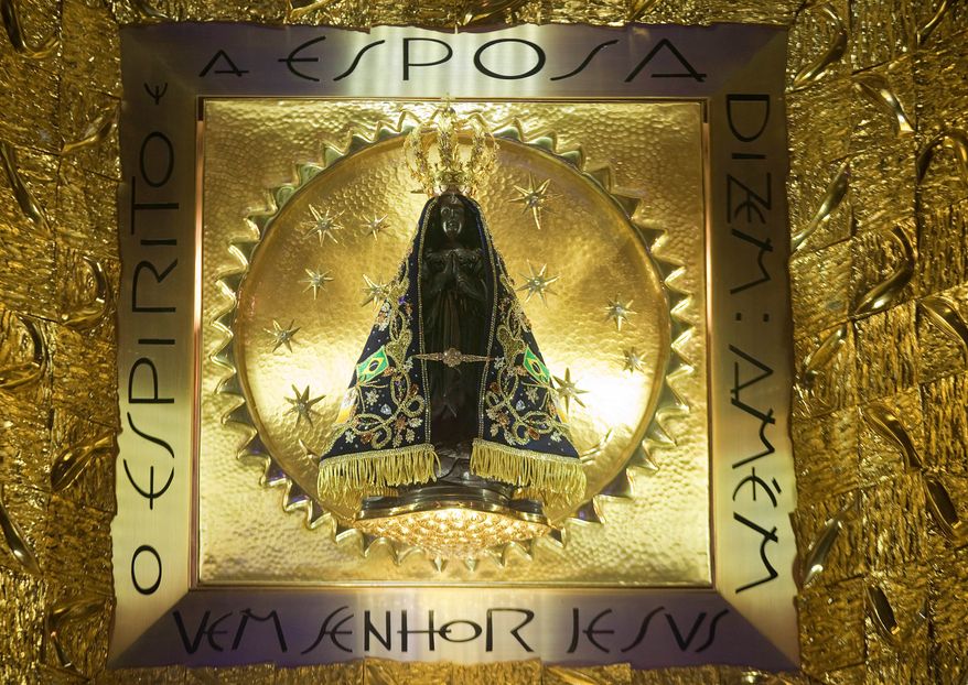 The statue of Brazil's patron saint, the Virgin of Aparecida, stands behind glass inside the basilica named after her in the town of Aparecida, Brazil, July 23, 2013. (AP Photo/Andre Penner, File)