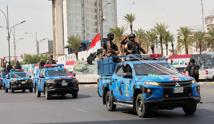 Iraqi police vehicles decorated with national flags and ribbons drive in a convoy as officers flash victory signs while celebrating the complete withdrawal of U.S. troops from Iraq, in Baghdad, Iraq, Wednesday, Sept. 30, 2026. (AP Photo/Hadi Mizban)