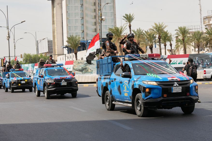 Iraqi police vehicles decorated with national flags and ribbons drive in a convoy as officers flash victory signs while celebrating the complete withdrawal of U.S. troops from Iraq, in Baghdad, Iraq, Wednesday, Sept. 30, 2026. (AP Photo/Hadi Mizban)