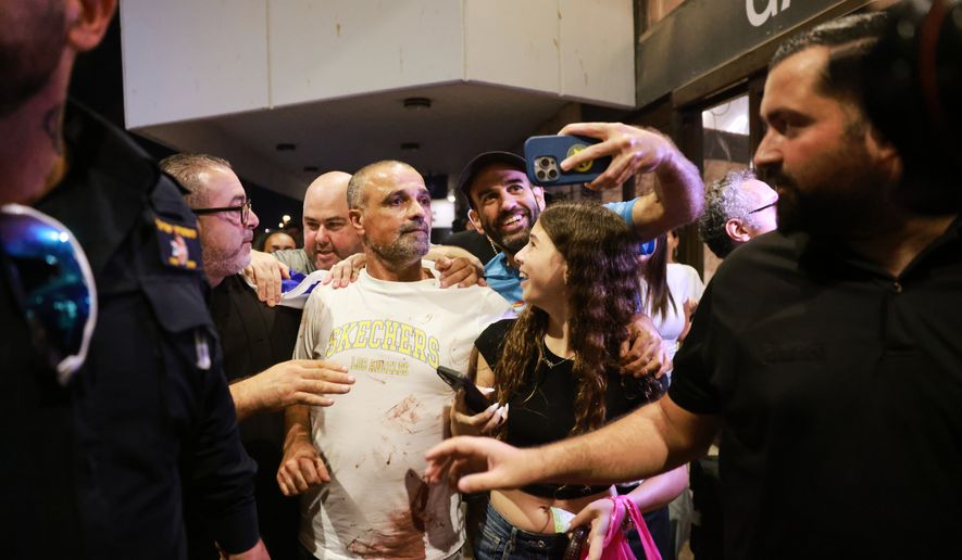 Israeli passenger Yaniv Hayoun, with blood stains on his shirt, who was aboard a Flydubai aircraft that made an emergency landing in Saudi Arabia, is welcomed at the arrivals gate at Ben Gurion International Airport near Tel Aviv, Israel, Wednesday, Sept. 30, 2026. (AP Photo/Tomer Appelbaum)