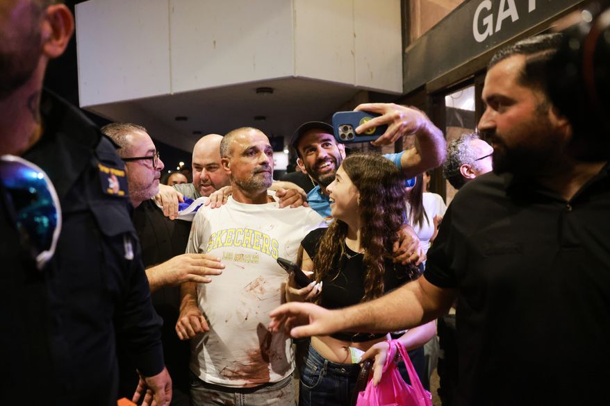 Israeli passenger Yaniv Hayoun, with blood stains on his shirt, who was aboard a Flydubai aircraft that made an emergency landing in Saudi Arabia, is welcomed at the arrivals gate at Ben Gurion International Airport near Tel Aviv, Israel, Wednesday, Sept. 30, 2026. (AP Photo/Tomer Appelbaum)