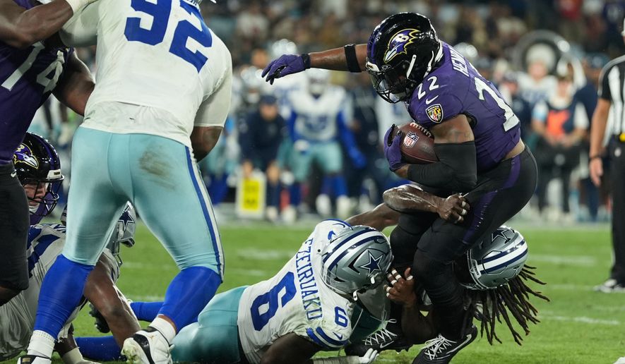 Baltimore Ravens running back Derrick Henry (22) is tackled by Dallas Cowboys linebacker Donovan Ezeiruaku (6) and linebacker Jaishawn Barham (55) during the second half of an NFL football game in Rio de Janeiro, Sunday, Sept. 27, 2026. (AP Photo/Fernando Llano)
