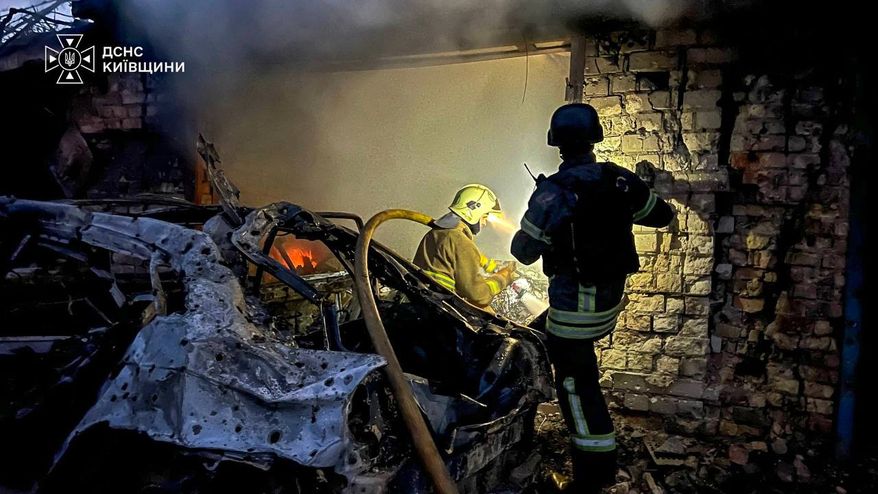 In this photo provided by the Ukrainian Emergency Services on Wednesday, Sept. 30, 2026, rescuers put out a fire in a garage destroyed after a Russian drone strike on Kyiv region, Ukraine. (Ukrainian Emergency Service via AP)