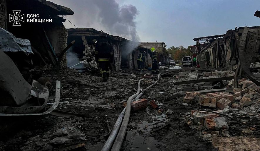 In this photo provided by the Ukrainian Emergency Services on Wednesday, Sept. 30, 2026, rescuers put out a fire affecting garages destroyed after a Russian drone strike on Kyiv region, Ukraine. (Ukrainian Emergency Service via AP)