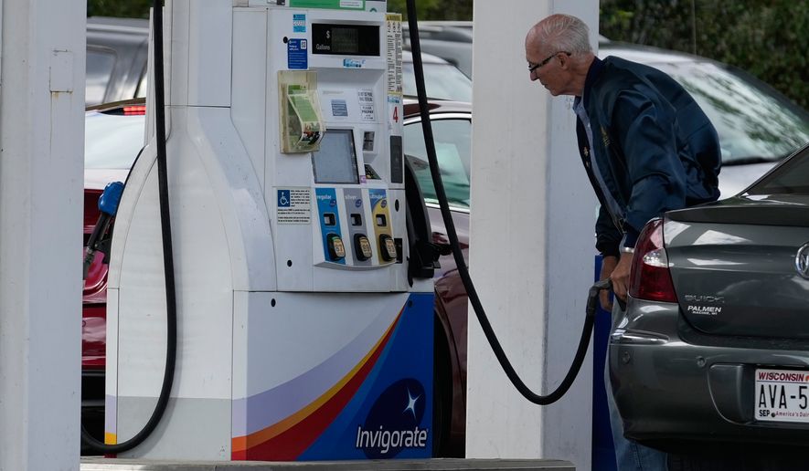 A customer checks gas prices while he fills up his vehicle's tank at a gas station in Racine, Wis., on Tuesday, Sept. 22, 2026. (AP Photo/Nam Y. Huh) ** FILE **