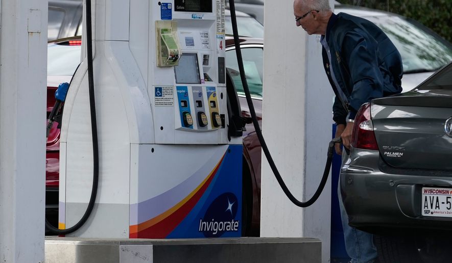A customer checks gas price while he fills up his vehicle's tank at a gas station in Racine, Wis., Tuesday, Sept. 22, 2026. (AP Photo/Nam Y. Huh)