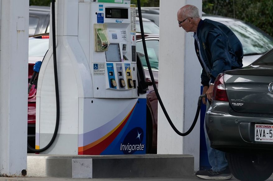 A customer checks gas price while he fills up his vehicle's tank at a gas station in Racine, Wis., Tuesday, Sept. 22, 2026. (AP Photo/Nam Y. Huh)